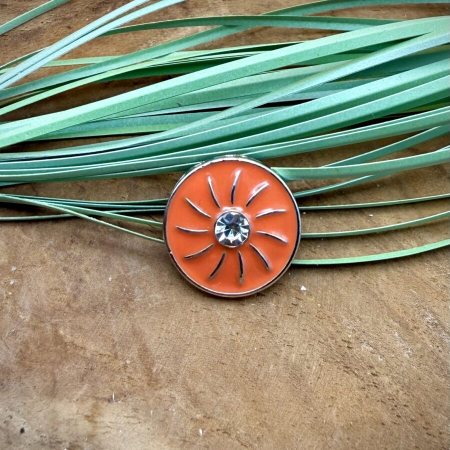 Bouton pression soleil corail interchangeable avec motif soleil argenté et strass central sur fond corail brillant