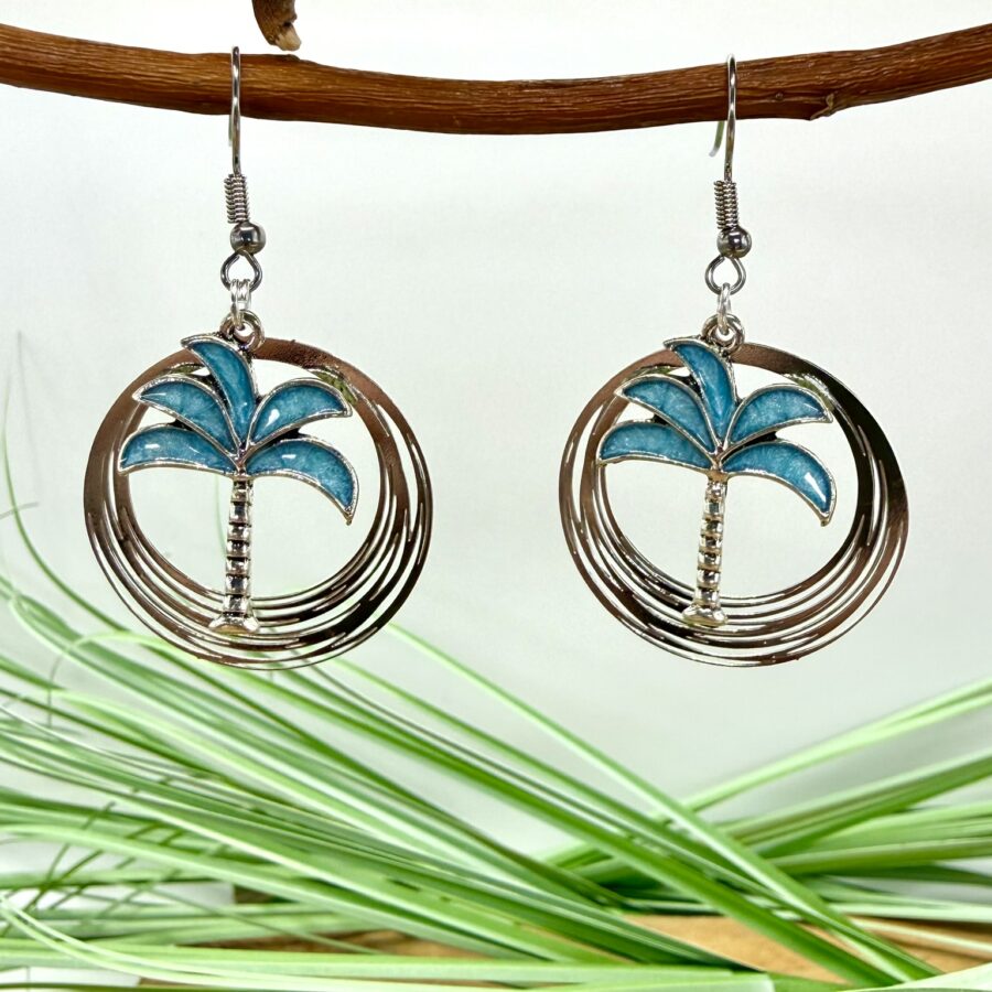 Boucles d'oreilles palmier Bali avec palmier bleu en métal émaillé suspendu dans une estampe ronde argentée ajourée et crochets en acier inoxydable