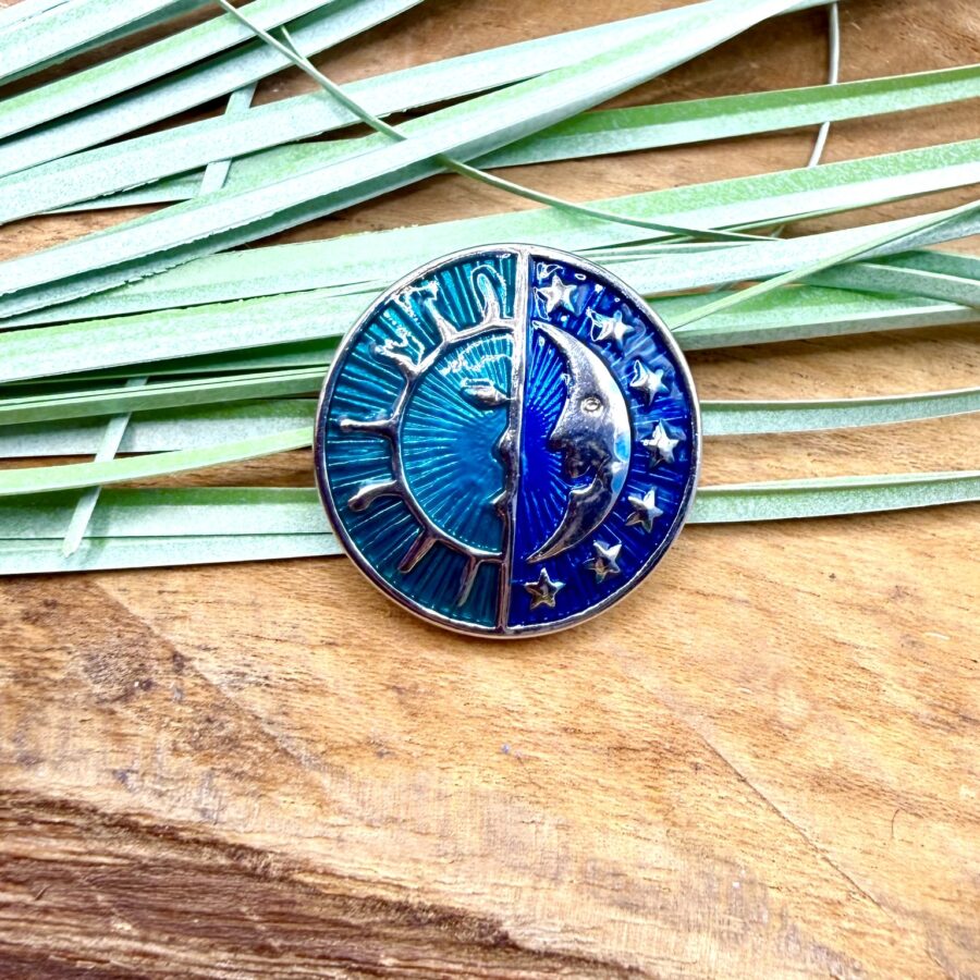 Bouton pression interchangeable rond bleu avec motif soleil, lune et étoiles en métal argenté.