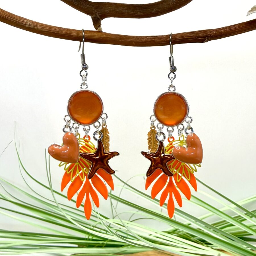 Boucles d’oreilles fantaisie orange avec cabochon rond et breloques colorées en forme de cœur, étoile de mer et feuillage.
