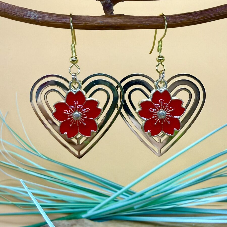 Boucles d'oreilles fleur rouge Sakura avec fleur rouge en métal émaillé suspendue dans une estampe cœur dorée ajourée et crochets en acier inoxydable
