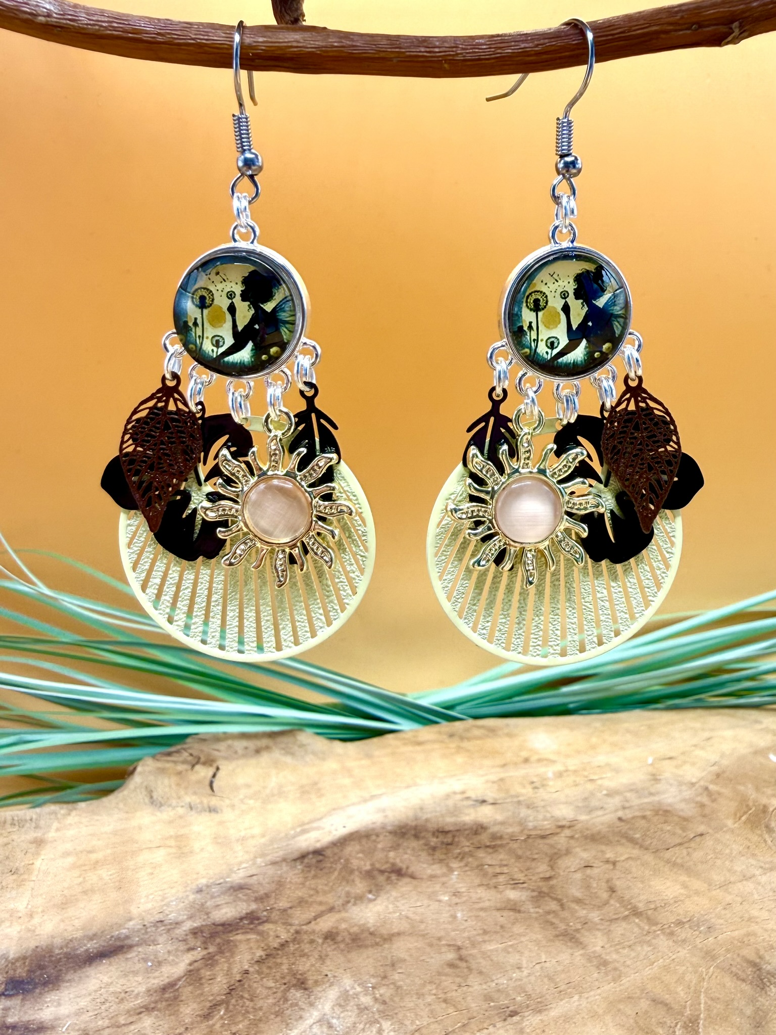 Boucles d'oreilles fée Aurore avec cabochon représentant une fée soufflant sur un pissenlit, soleil saumoné, fleur noire décorative et pendentif crème ajouré en acier inoxydable