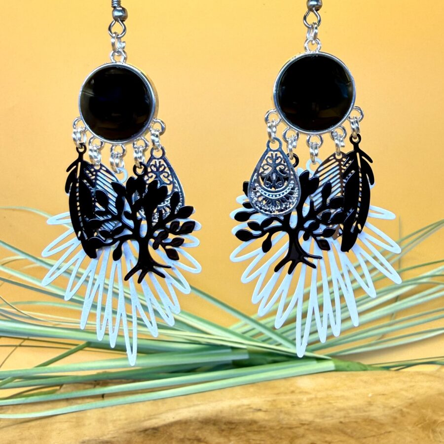 Boucles d'oreilles arbre de vie avec cabochon noir, feuilles décoratives noires et grande estampe blanche ajourée.