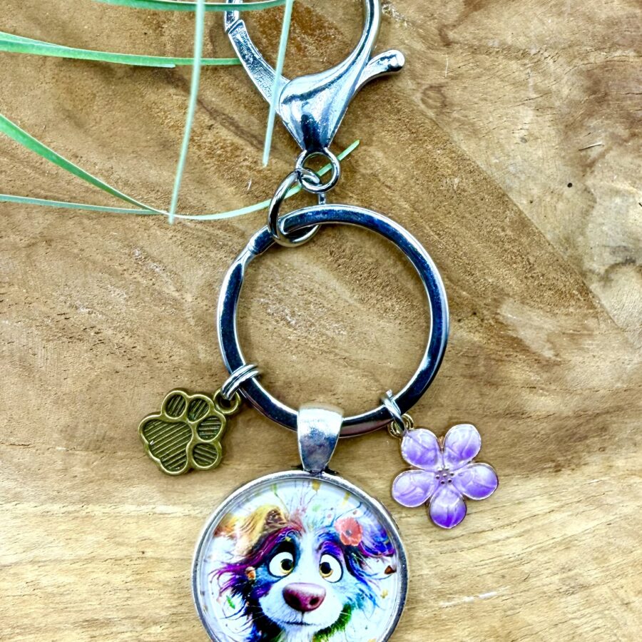 Porte-clés chien en acier inoxydable avec cabochon de 25 mm représentant un chien coloré, breloque patte et fleur violette émaillée.