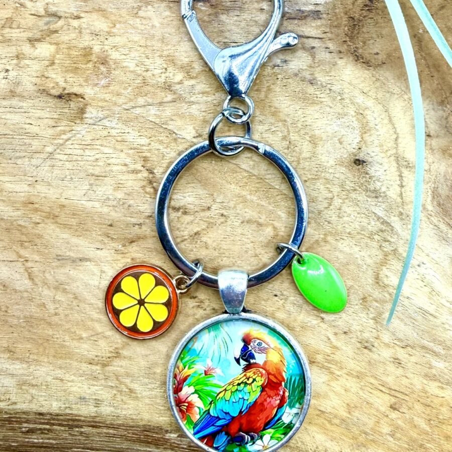 Porte-clés perroquet en acier inoxydable avec cabochon de 25 mm représentant un perroquet tropical coloré, breloque fleur jaune et breloque verte.
