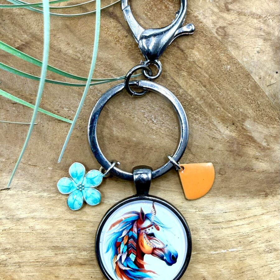 Porte-clés cheval en acier inoxydable avec cabochon représentant une tête de cheval colorée, breloque fleur turquoise et breloque orange.